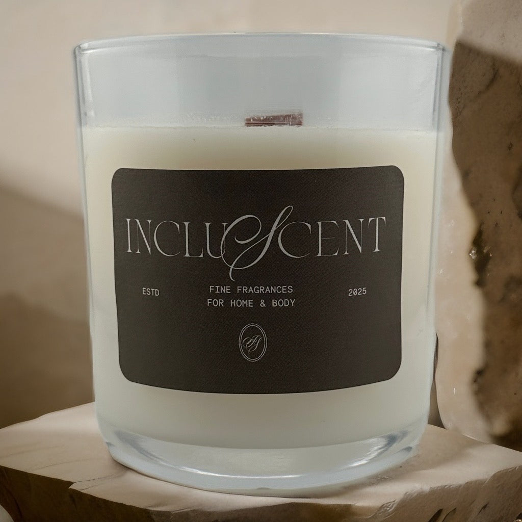 Incluscent candle in a glass jar with a label on a wooden surface