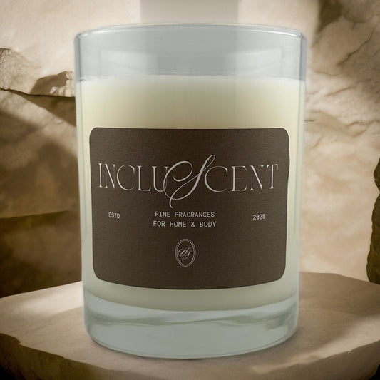 A candle in a glass jar on top of a piece of circular cut wood. 